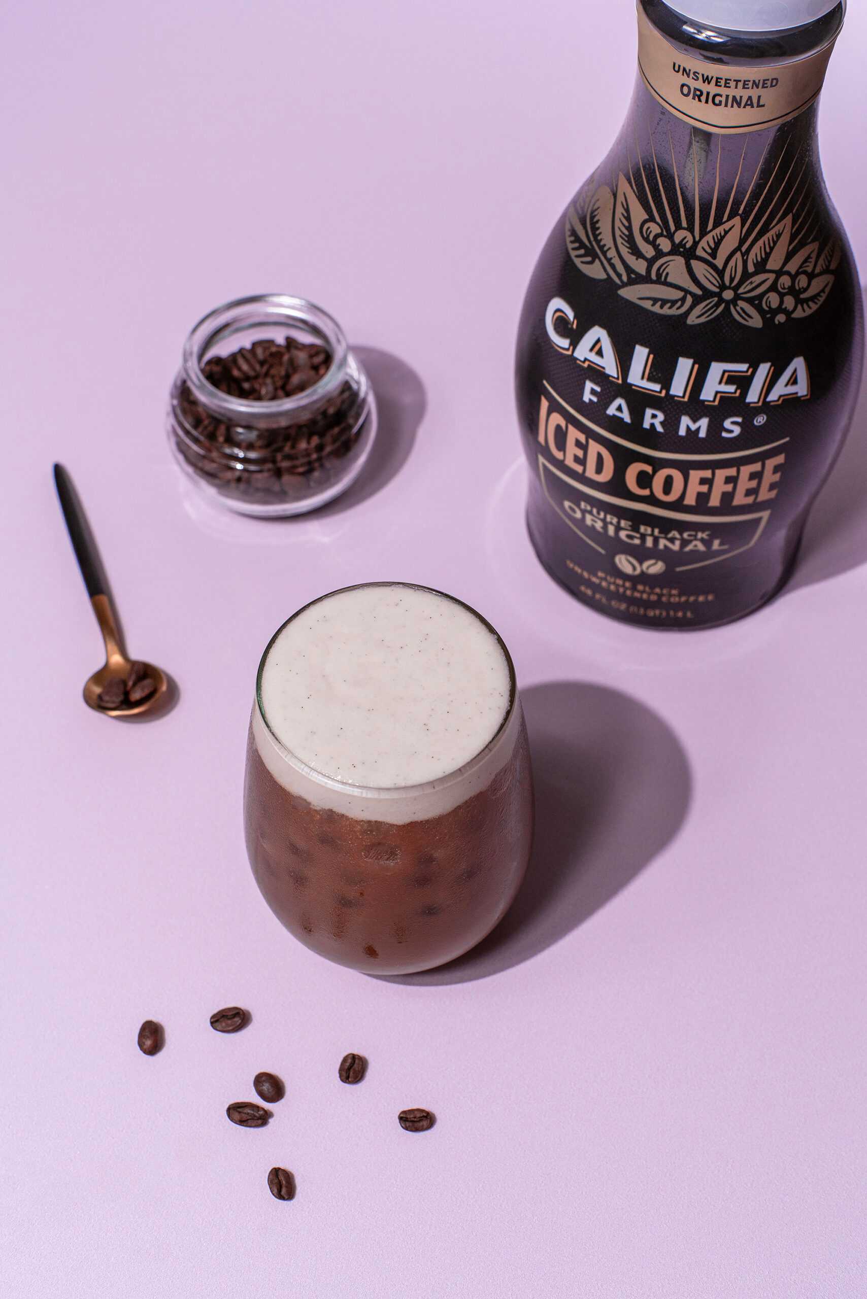 A sparkling iced coffee drink sits at the center of the image with Califia Farms Iced Coffee in the background.