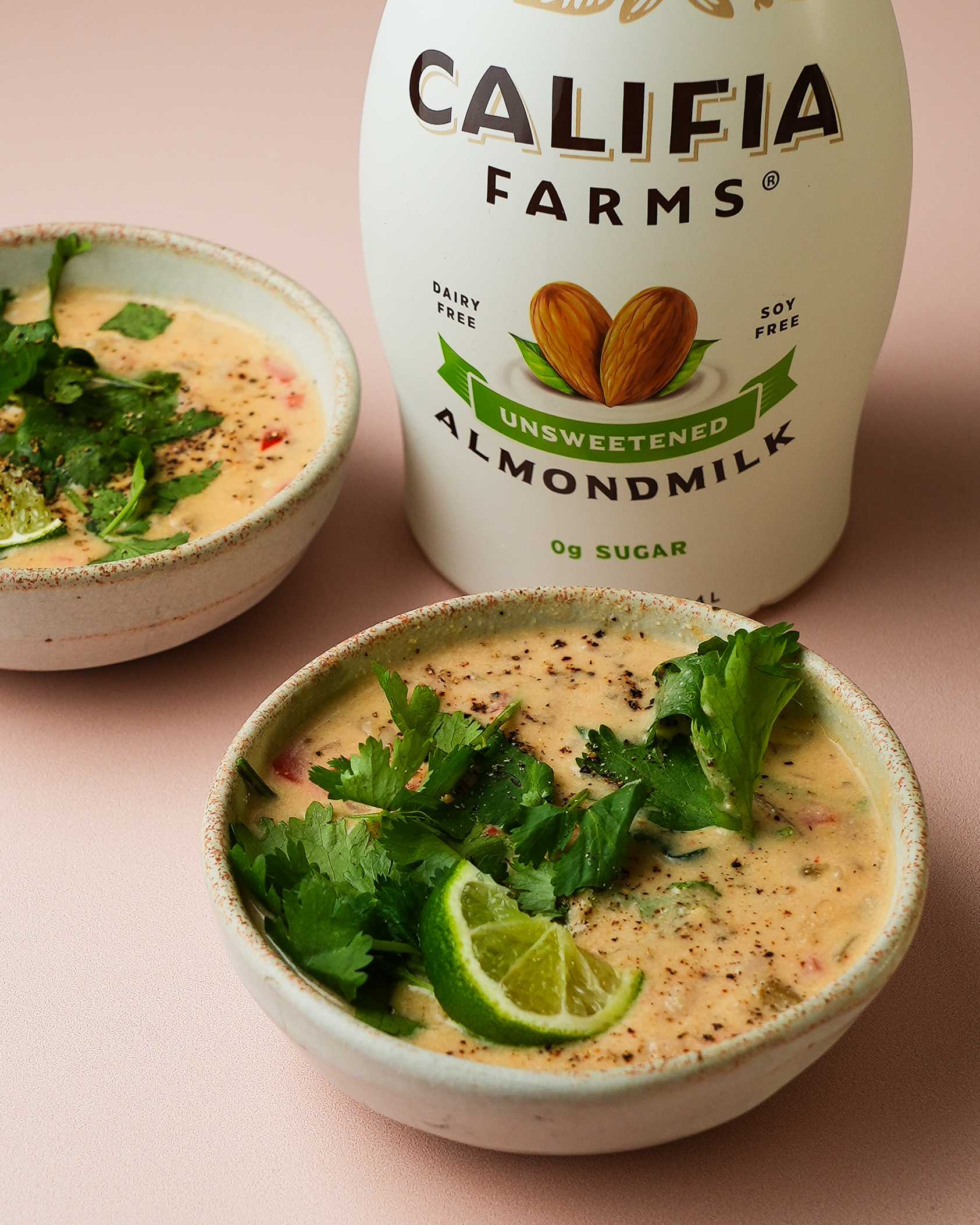 A bowl of chili sits at the forefront of the image, with Califia Farms Unsweetened Almondmilk in the background