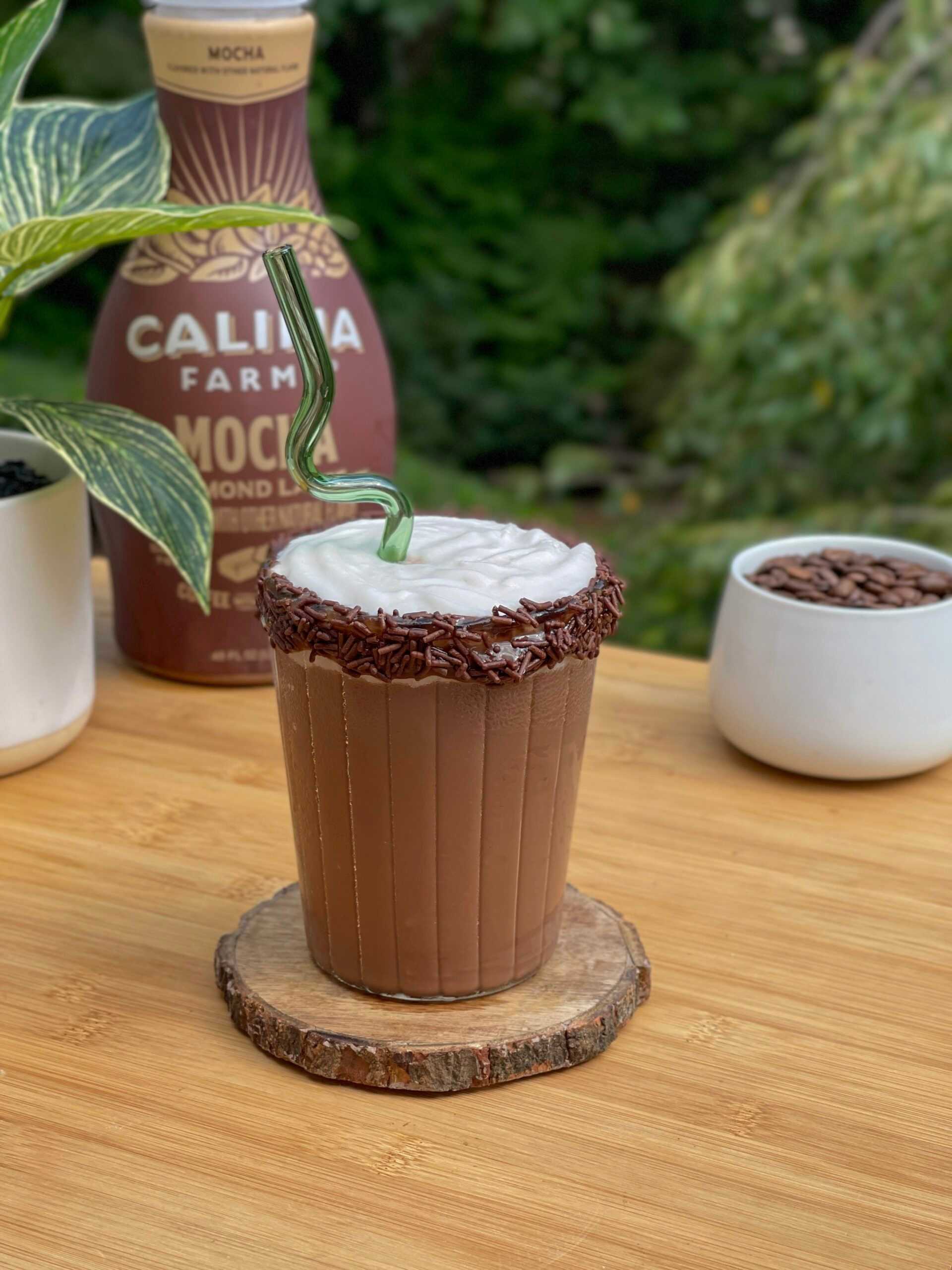 A mocha frappuccino sits in the center of the image, with Califia Farms Mocha Latte in the background.